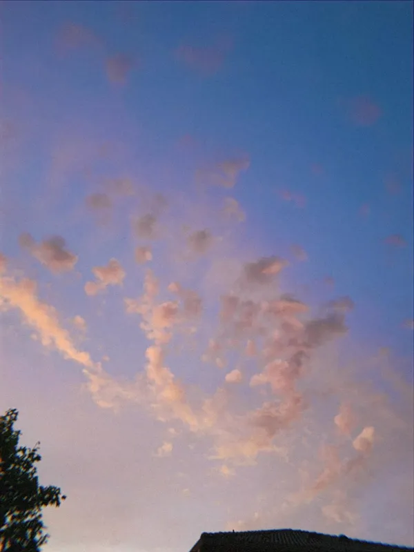 Scattered pink clouds across a soft blue sky